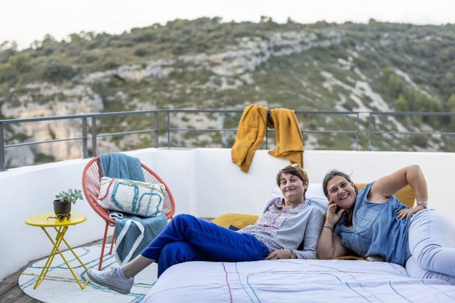Deux femmes allongées sur un lit sur une terrasse