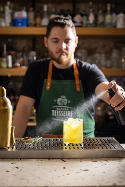 Barman aspergeant un cocktail avec un vaporisateur