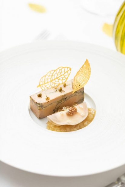 Entrée à base de foie gras dans une grande assiette blanche