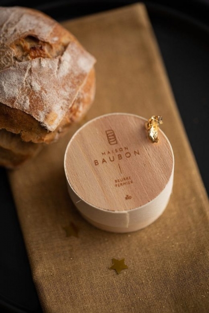 Boîte en bois sur une planchette en bois, à côté d'une miche de pain