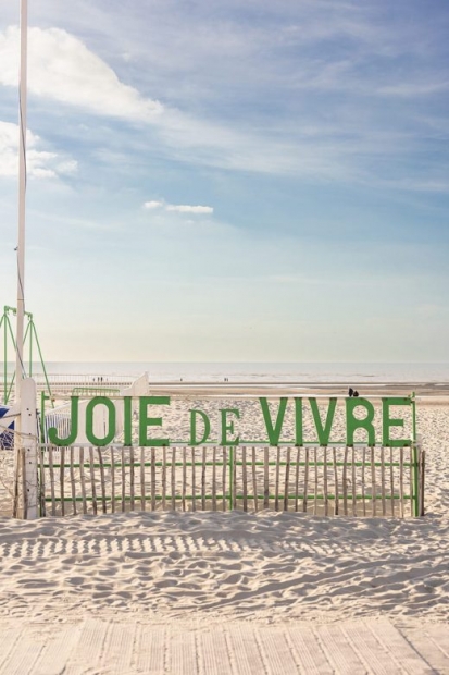 Lettres vertes formant les mots Joie de vivre, sur une plage