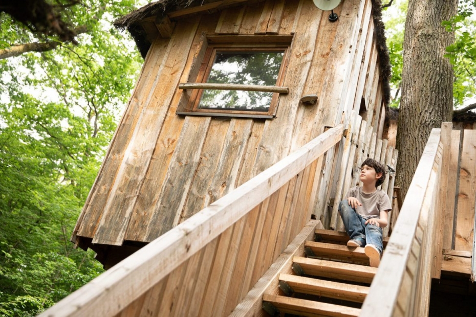 Enfant dans l'escalier d'une cabane en bois