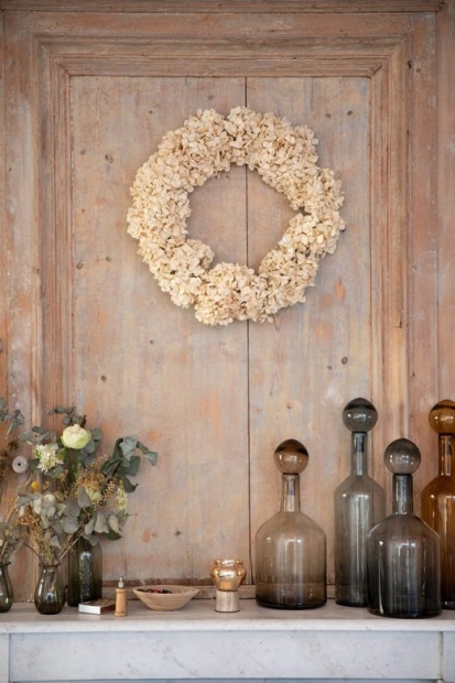 Vases et couronne de fleurs séchées sur fond bois