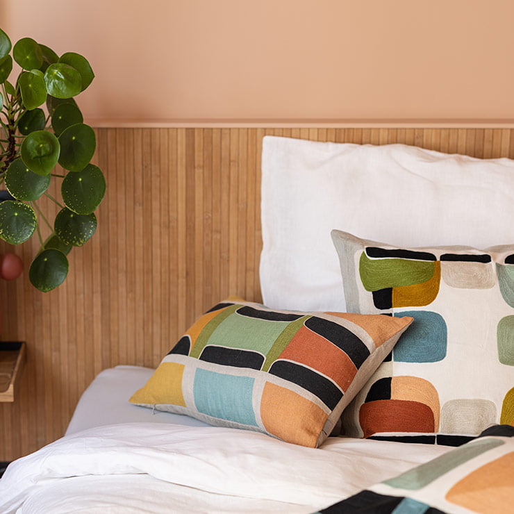 Coussins à motifs géométrique posés sur un lit